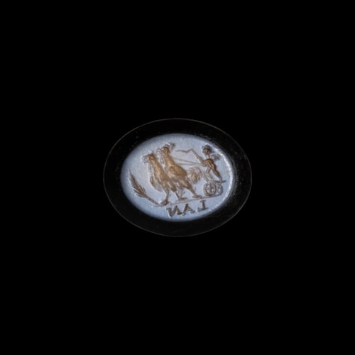 A Roman nicolo intaglio. Eros riding a chariot pulled by two roosters.